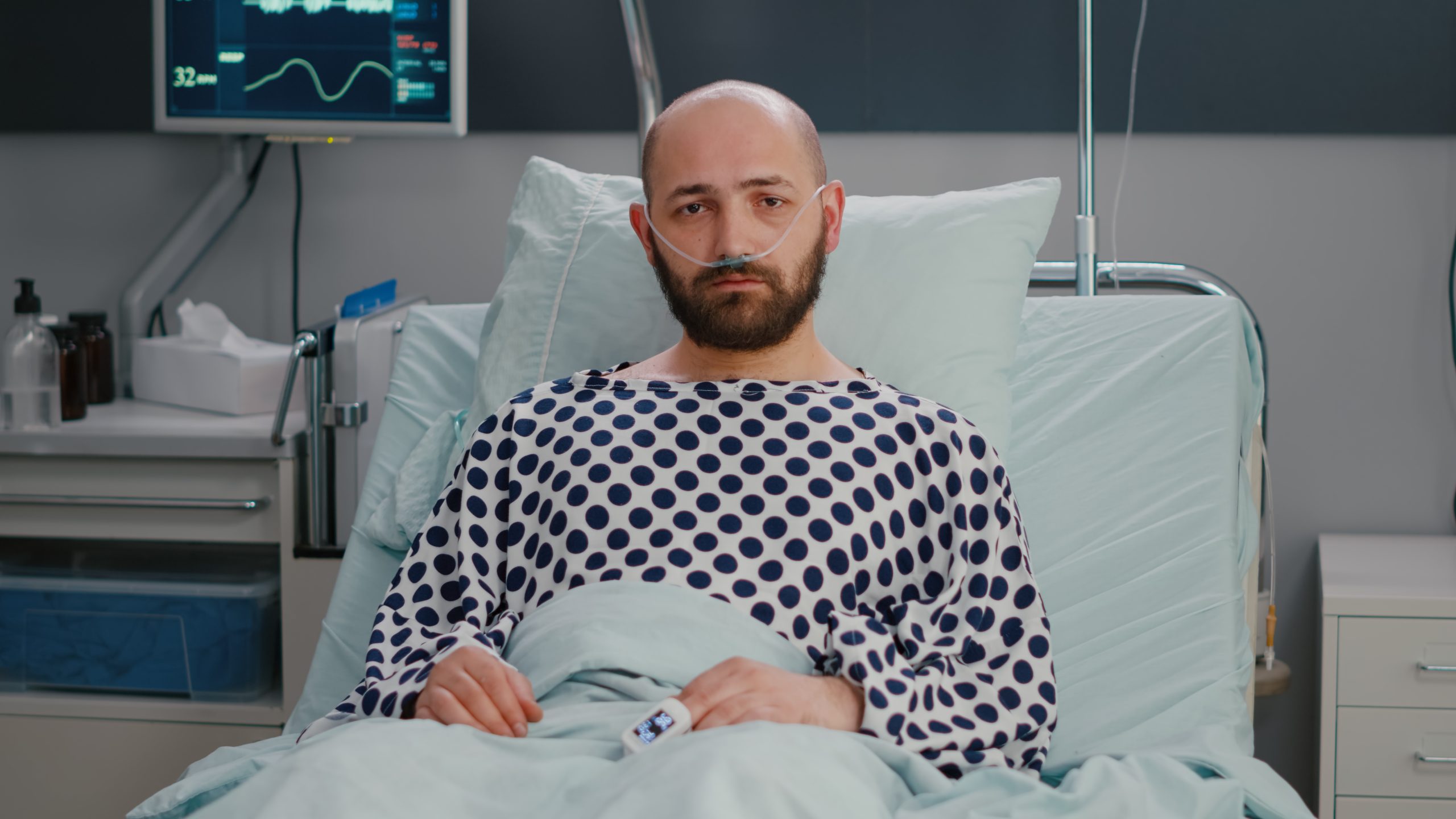 Homem doente com expressão triste em uma cama de hospital